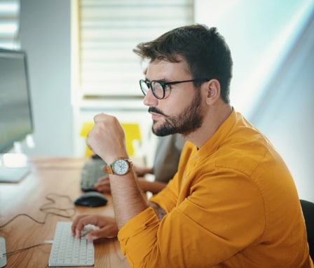 Man at work looking at his computer monitors