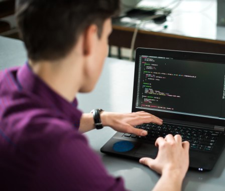 Man coding on laptop