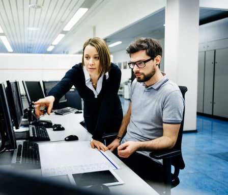 Person helps someone working on a computer