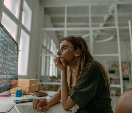 Female programmer coding on a desktop computer