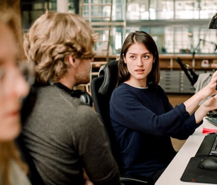 Coworker explaining to colleague while sitting in office. Credit: Maskot / Maskot / Getty Images