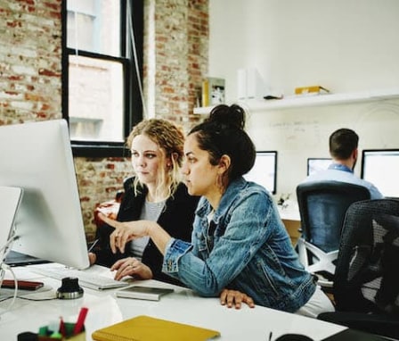 Two women working together on a computer