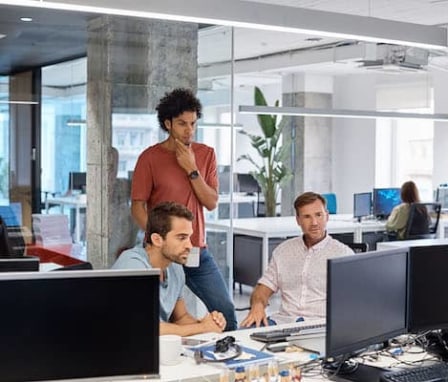 Three colleagues working together on a computer