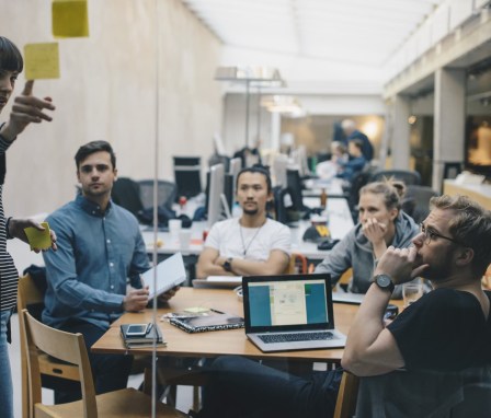 Woman giving presentation to casual group meeting