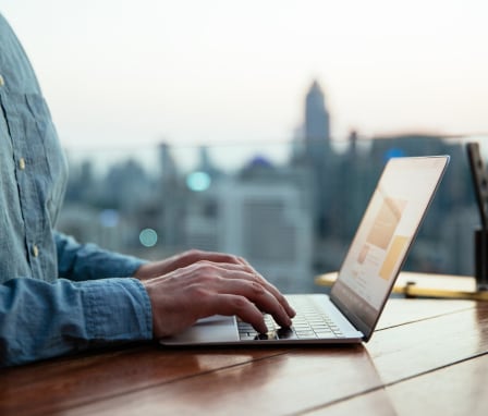 Hands typing on laptop