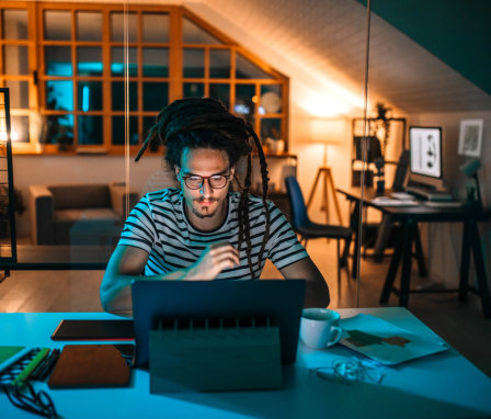 Man working on computer at home at night