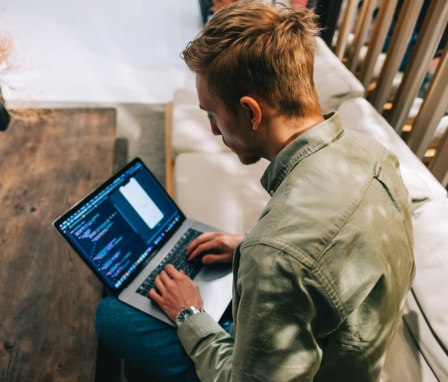 Person coding an app on a laptop