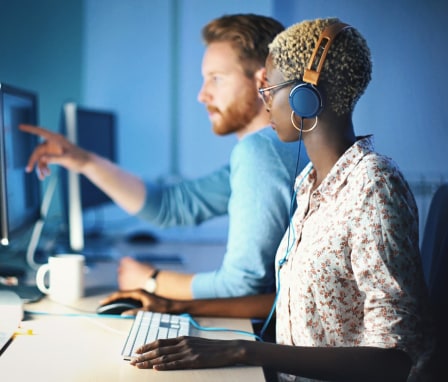 Two colleagues coding on computers